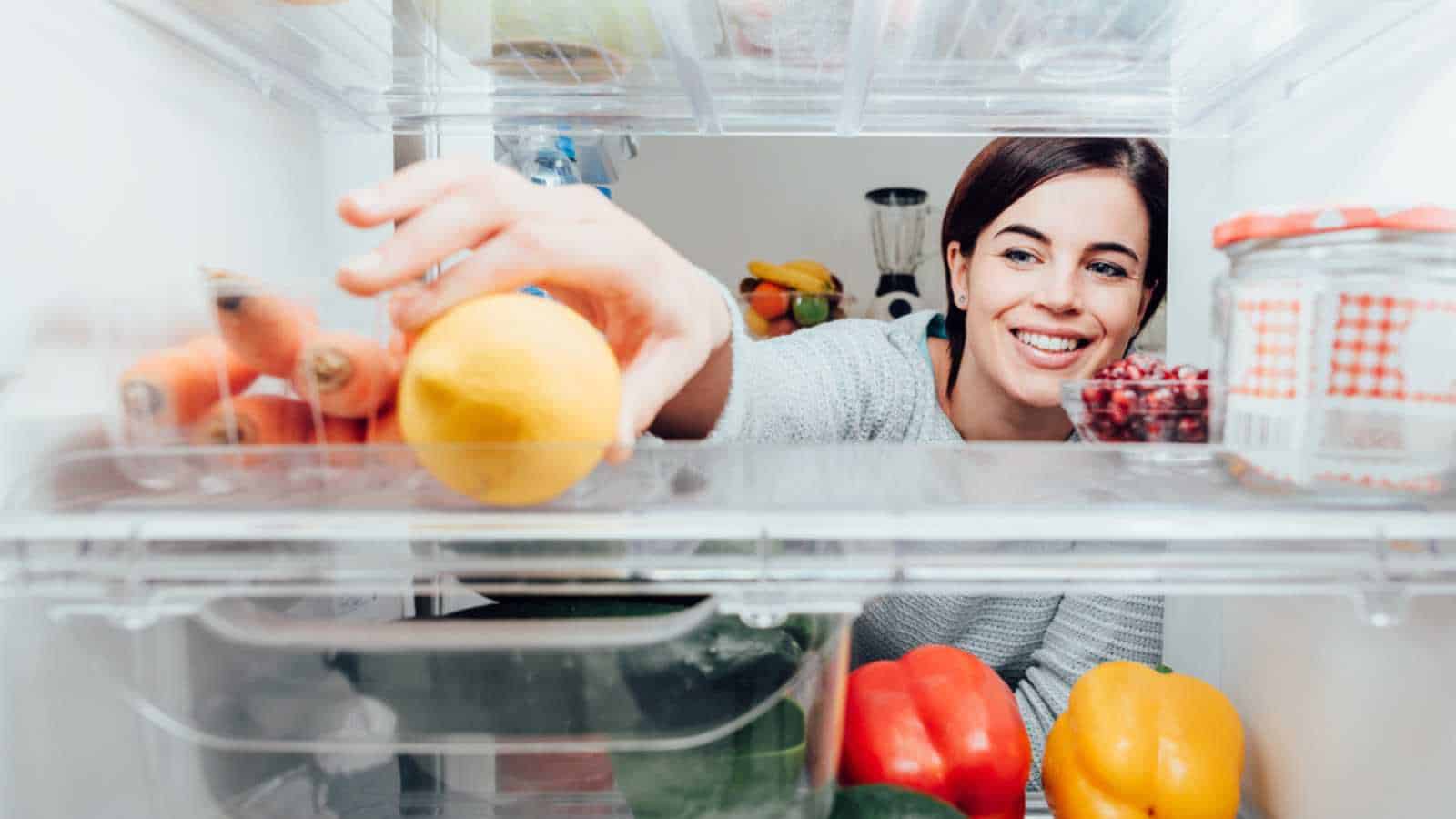 Woman taking fruit from freezer
