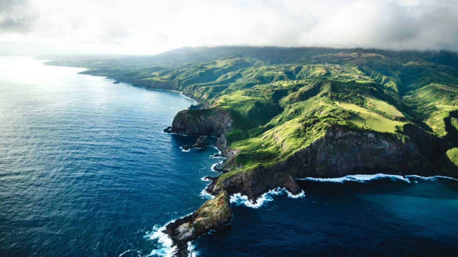 Beautiful Aerial View of Tropical Island Paradise Nature Scene of Maui Hawaii On Clear Sunny Day with Vibrant Blue Ocean Water and Waves and Lush Green Mountain Scenic Landscape