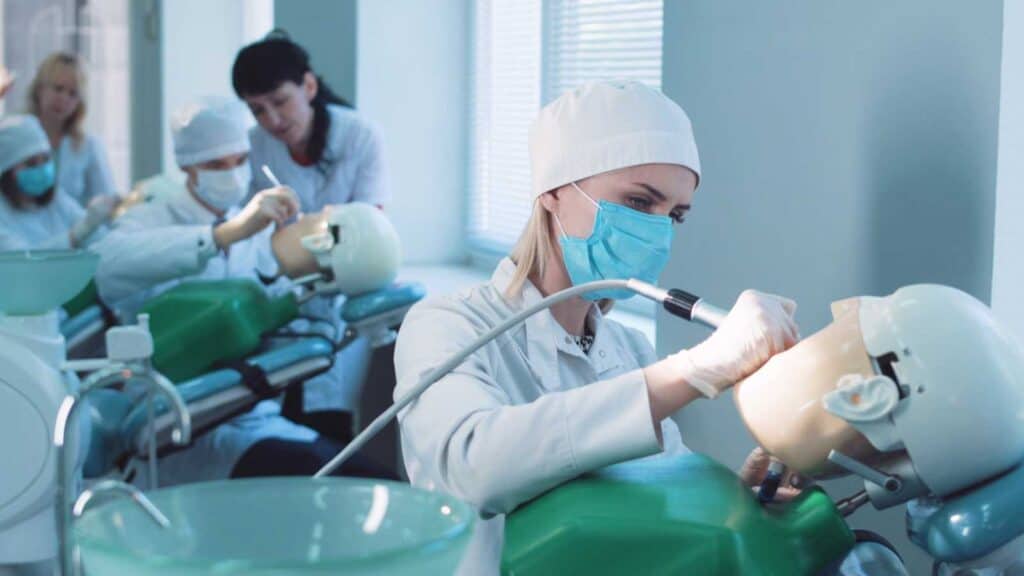 Students practicing dentistry on medical dummies in a teaching facility or university