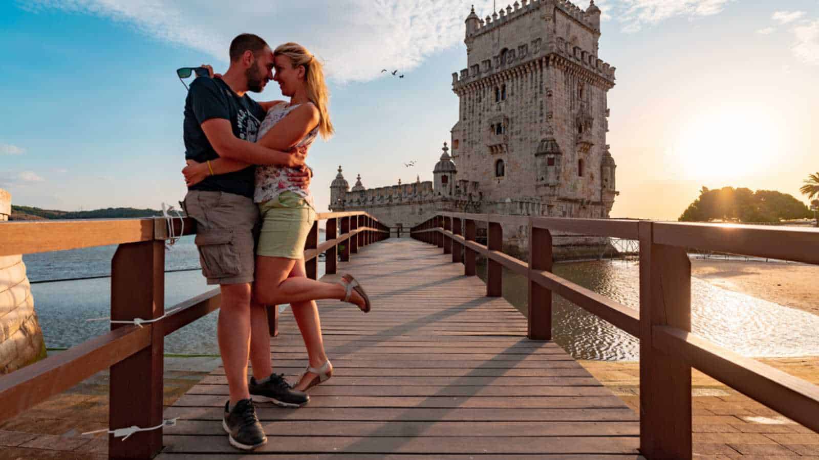 Couple in love on a small bridge leading to tower of Belem in Lisbon