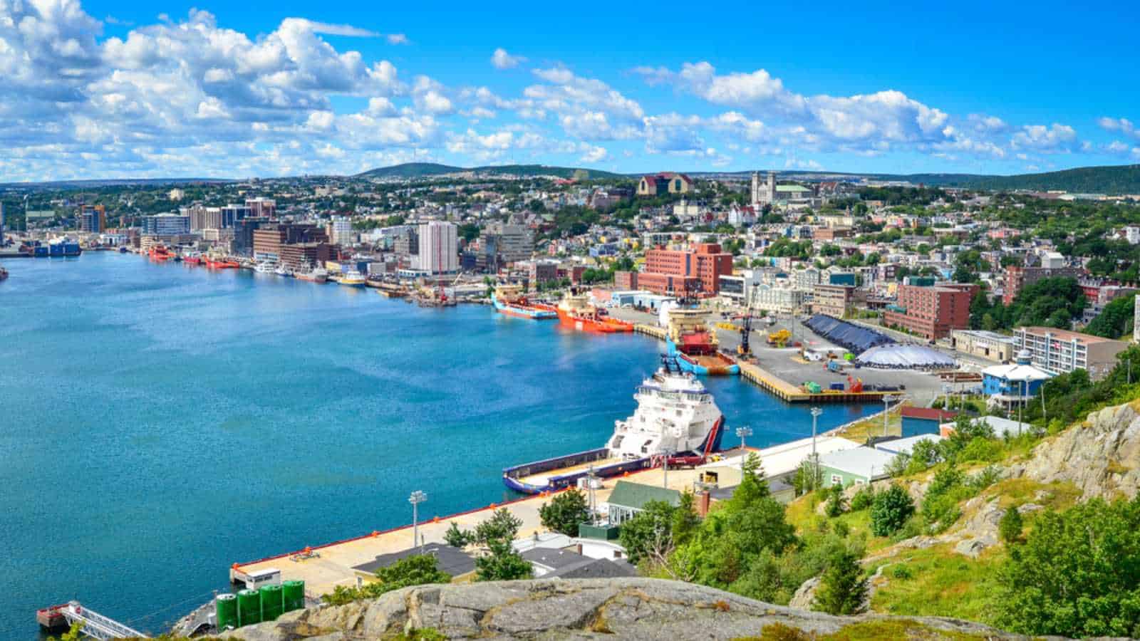 Panoramic views with bight blue summer day sky with puffy clouds over the harbor and city of St. John's NewFoundland, Canada.