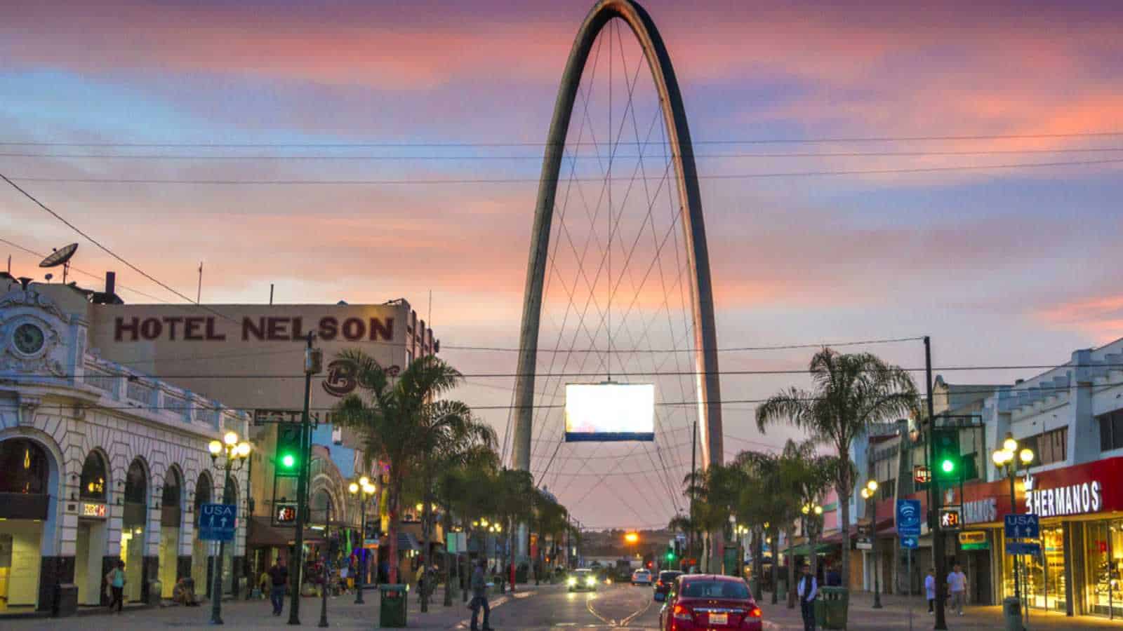 TIJUANA, MEXICO - APRIL 26, 2017: Avenida Revolucion (Revolution street), the main touristic artery in Tijuana, with the millennial arch (el arco y reloj monumental) in a perspective at dusk