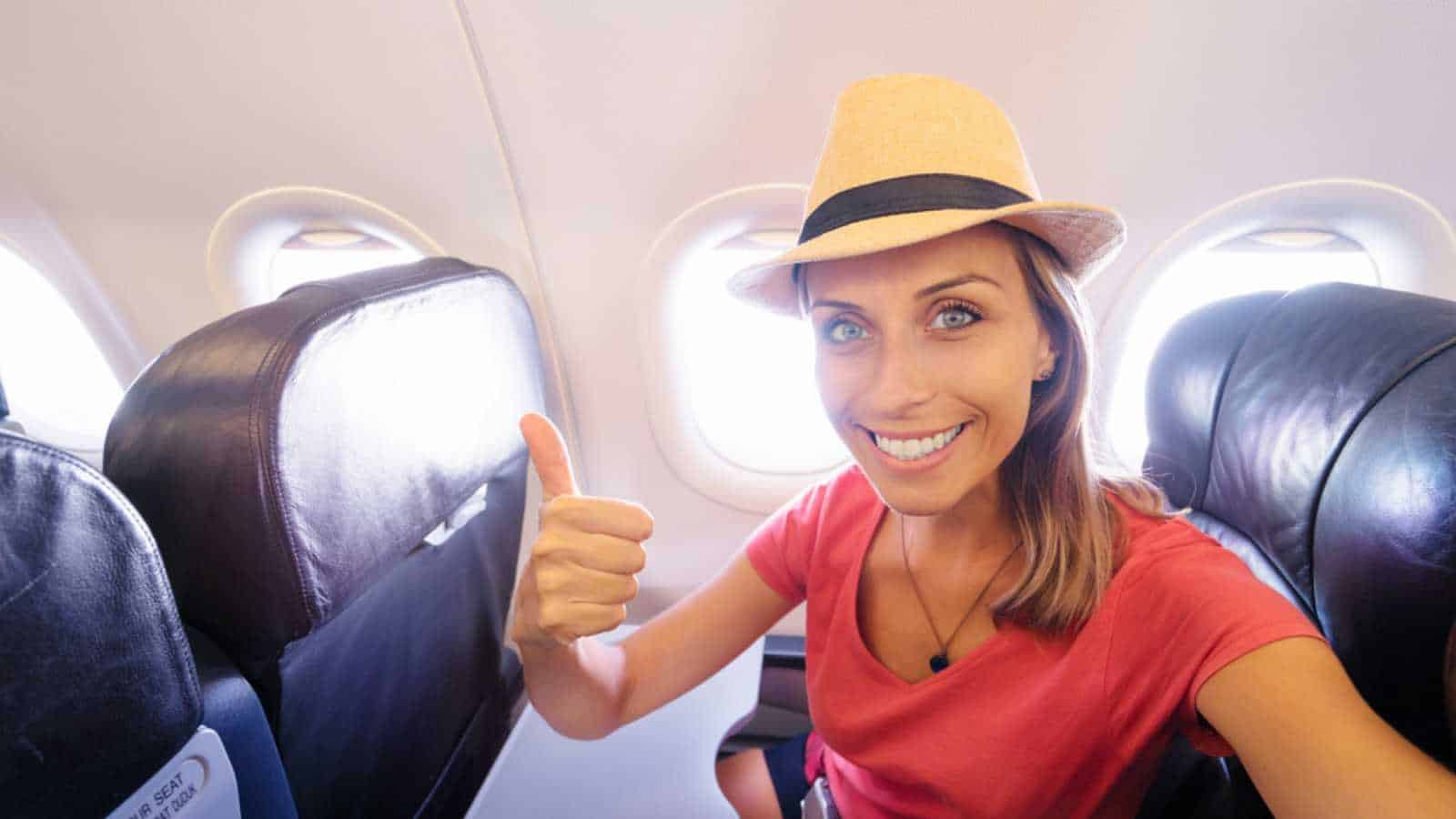 Woman traveling in flight taking selfie