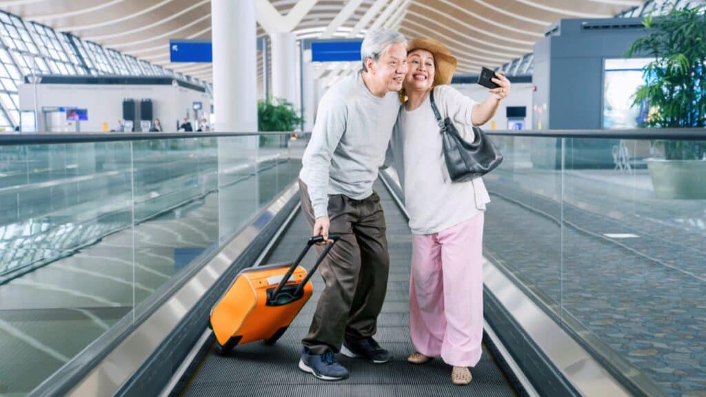 Senior couples taking selfie at airport