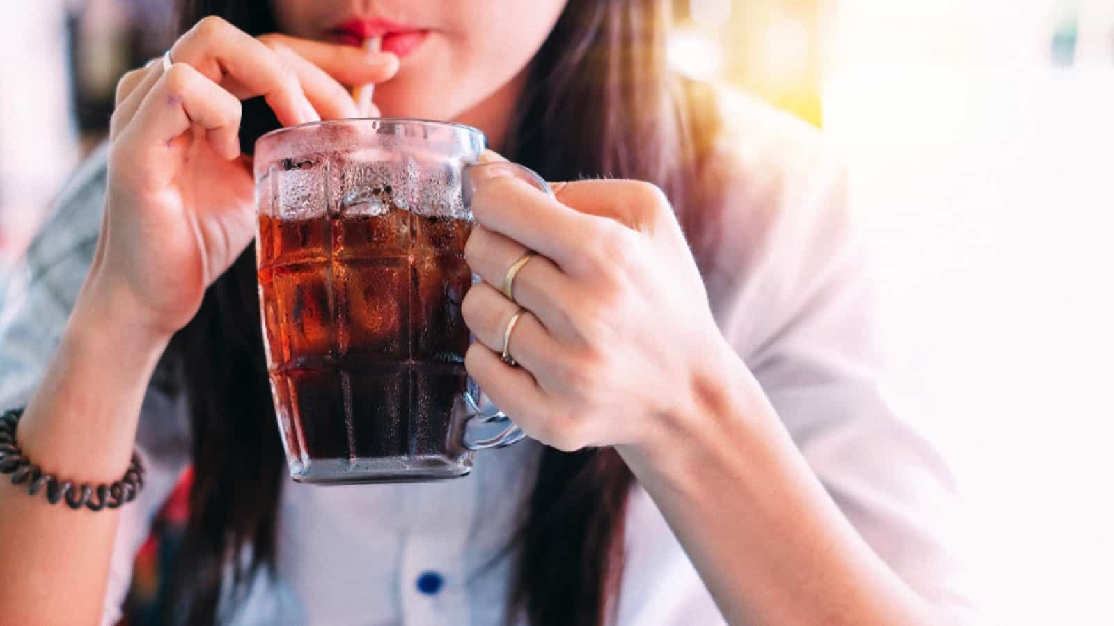 Woman drinking coke with ice cubes
