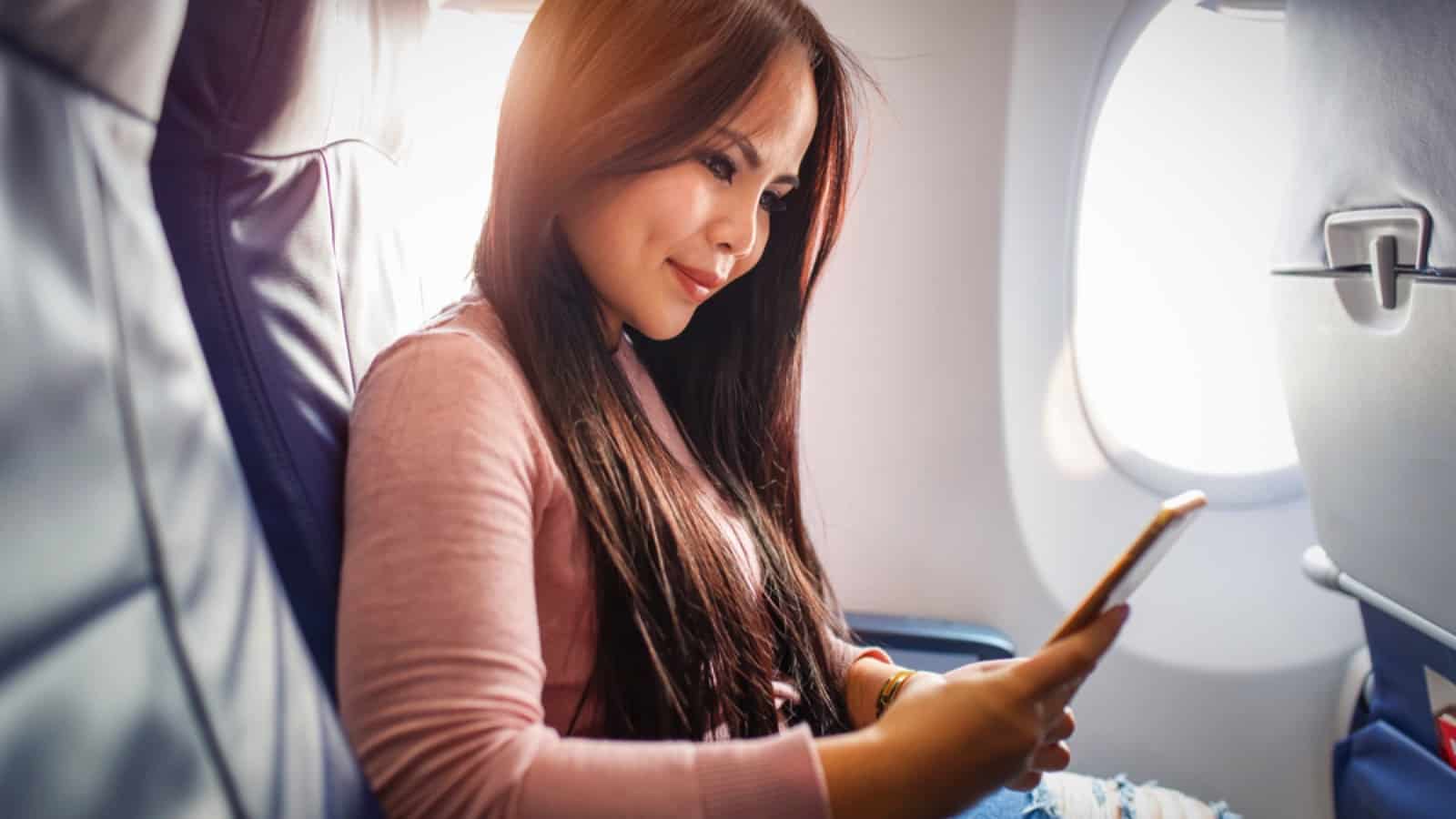 Woman using mobile inside flight