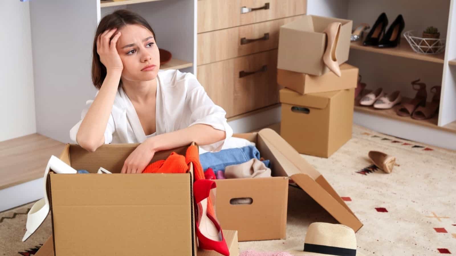 Upset young woman with wardrobe box