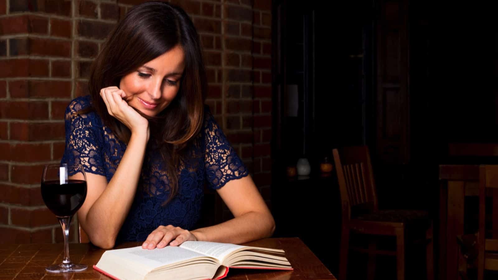 Woman reading book in bar